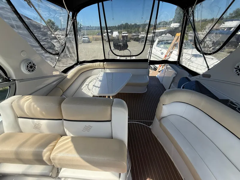 Slide: The Image of Interior of 2008 Four Winns V358 boat with seating and table, featuring clear canopy. - 11