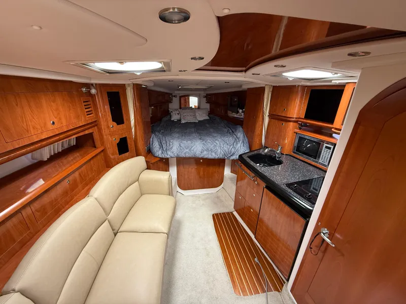 Slide: The Image of Luxurious 2008 Four Winns V358 yacht interior with wood finish, kitchenette, and cozy sleeping area. - 18