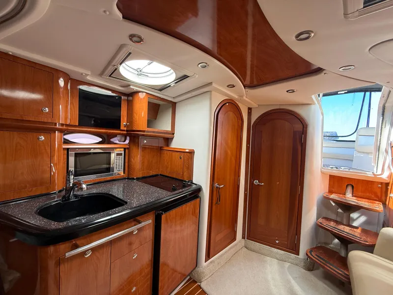 Slide: The Image of Luxurious 2008 Four Winns V358 yacht interior with wood cabinetry and modern amenities. - 19