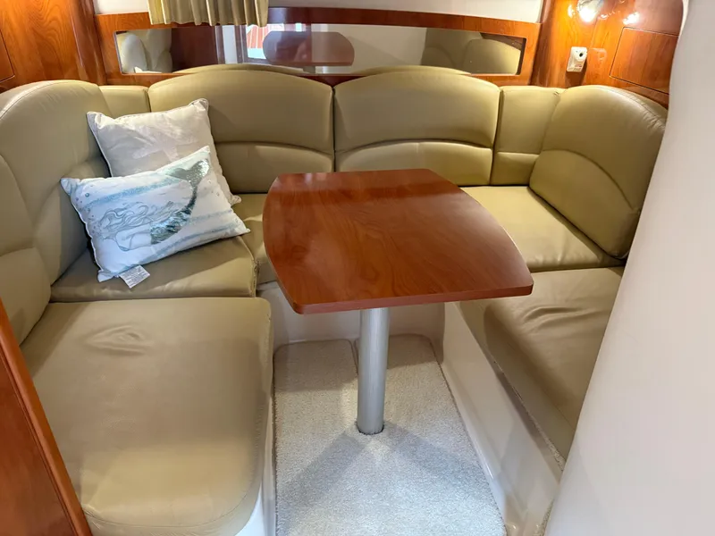 Slide: The Image of 2008 Four Winns V358 cabin interior with beige seating and wooden table. - 22