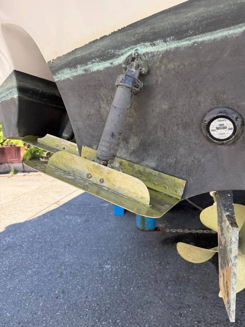 Slide: The Image of 2008 Four Winns V358 boat stern with trim tabs and propeller detail. - 25