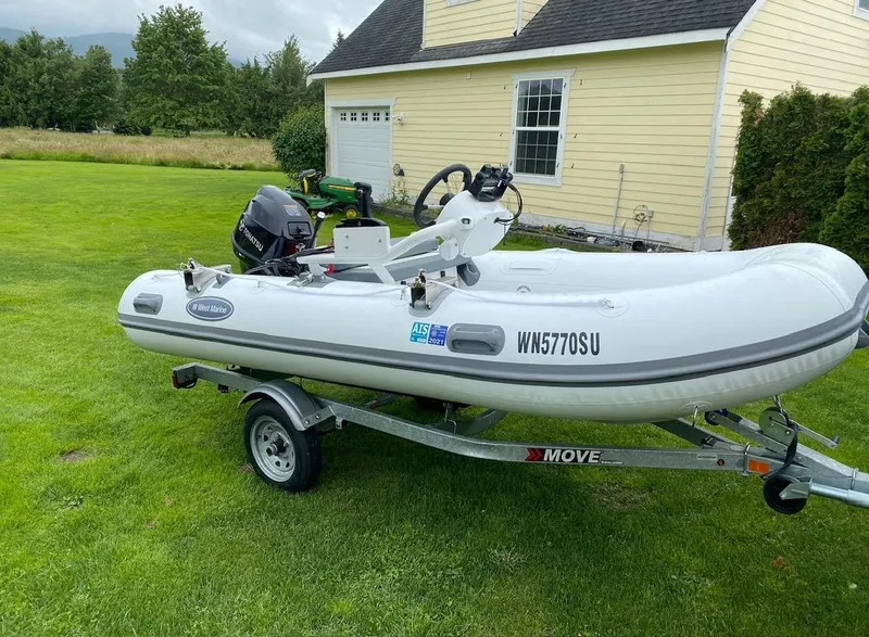 Slide: The Image of Inflatable boat on trailer in front of yellow house, featuring Tohatsu motor. - 7