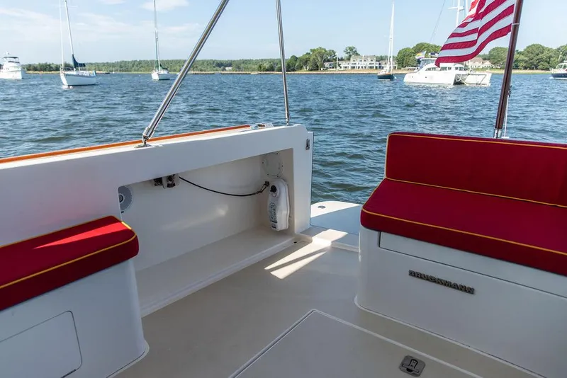 Slide: The Image of Bruckmann Abaco 40 yacht deck with red seating, overlooking calm waters and sailboats. - 23
