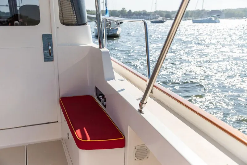 Slide: The Image of Bruckmann Abaco 40 boat deck with red cushioned seat, overlooking sparkling water. - 24
