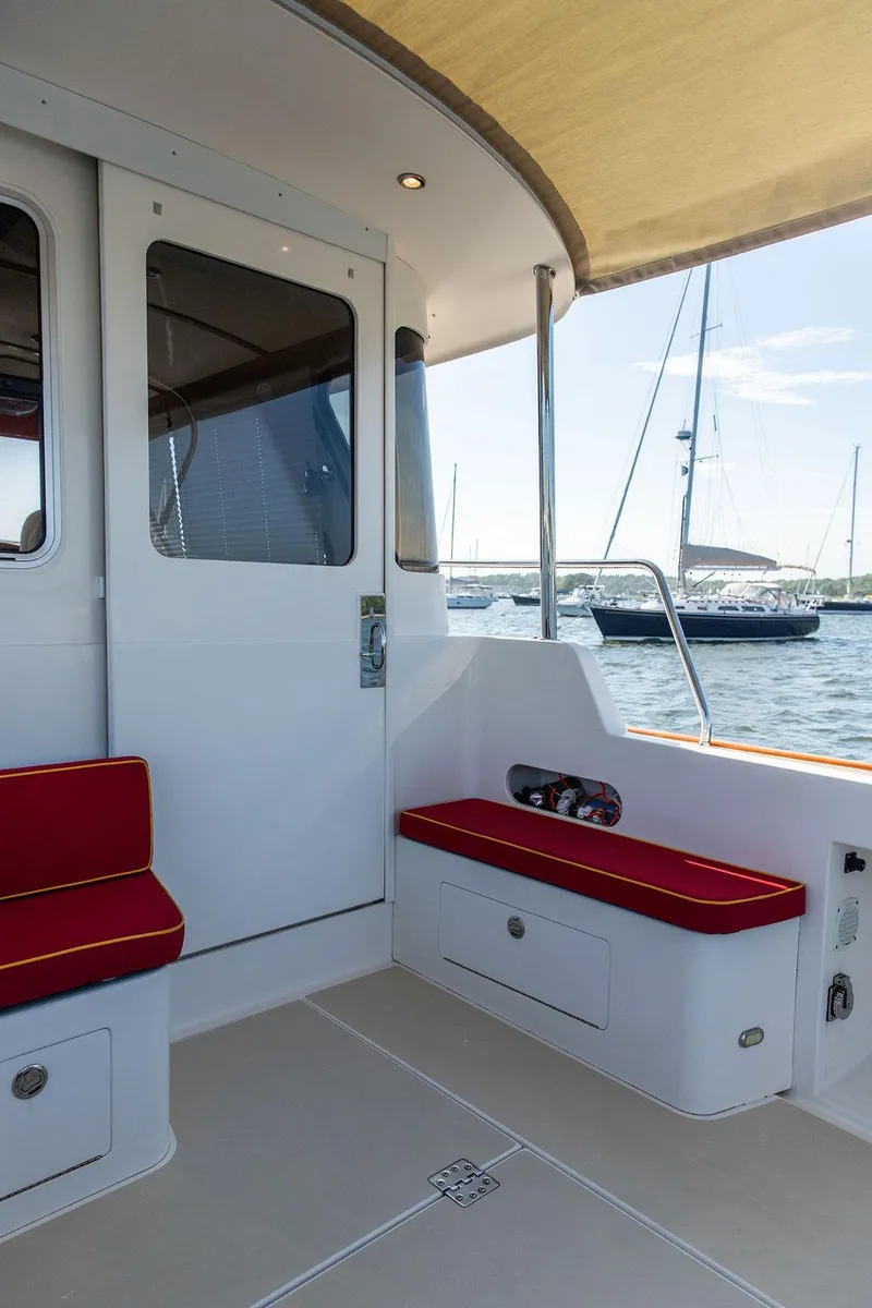 Slide: The Image of Bruckmann Abaco 40 yacht deck, 2014 model, featuring red cushioned seating and scenic marina view. - 25