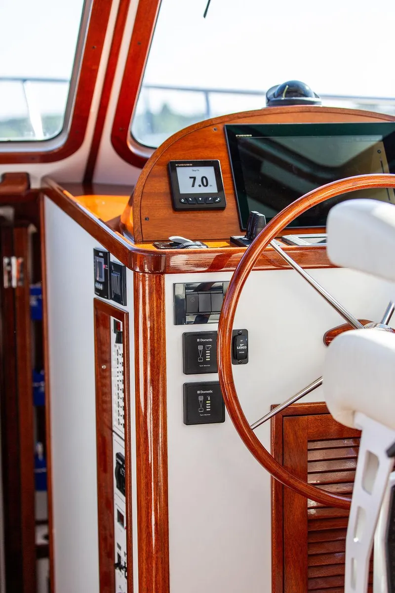Slide: The Image of Steering wheel and dashboard of 2014 Bruckmann Abaco 40 yacht, featuring wood accents and digital display. - 43