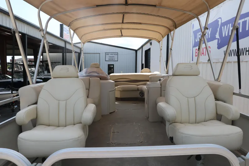 Slide: The Image of 2007 Bennington 2577 RFi pontoon boat with beige seating and canopy, docked at a marina. - 10