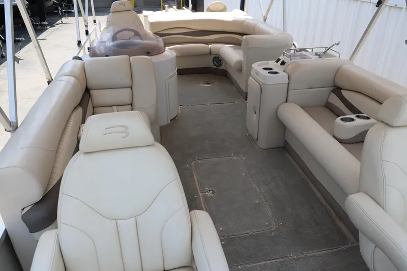 Slide: The Image of 2007 Bennington 2577 RFi pontoon boat interior with beige seating and helm. - 11