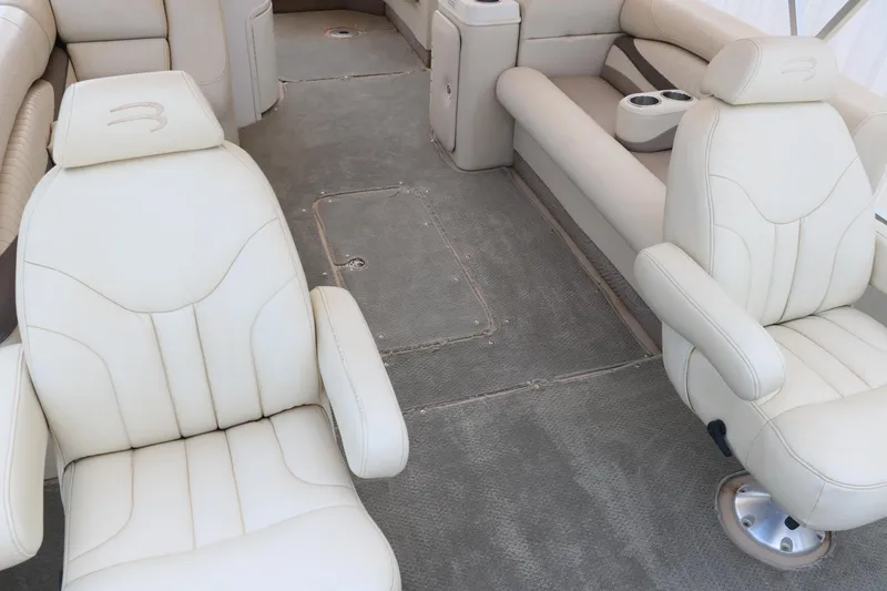 Slide: The Image of 2007 Bennington 2577 RFi boat interior with plush white seating and carpeted floor. - 12