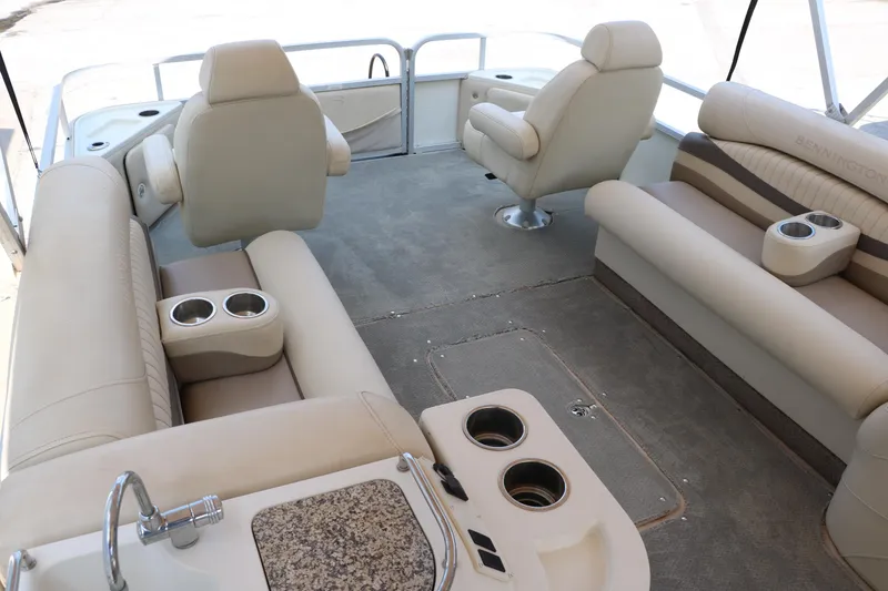 Slide: The Image of Interior of a 2007 Bennington 2577 RFi pontoon boat with beige seating and cup holders. - 20