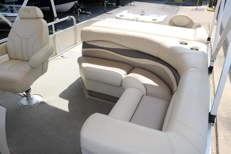 Slide: The Image of 2007 Bennington 2577 RFi boat interior with beige seating and cup holders. - 22