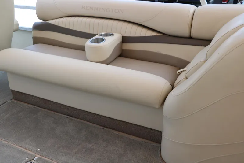 Slide: The Image of 2007 Bennington 2577 RFi boat interior with beige seating and built-in cup holders. - 24