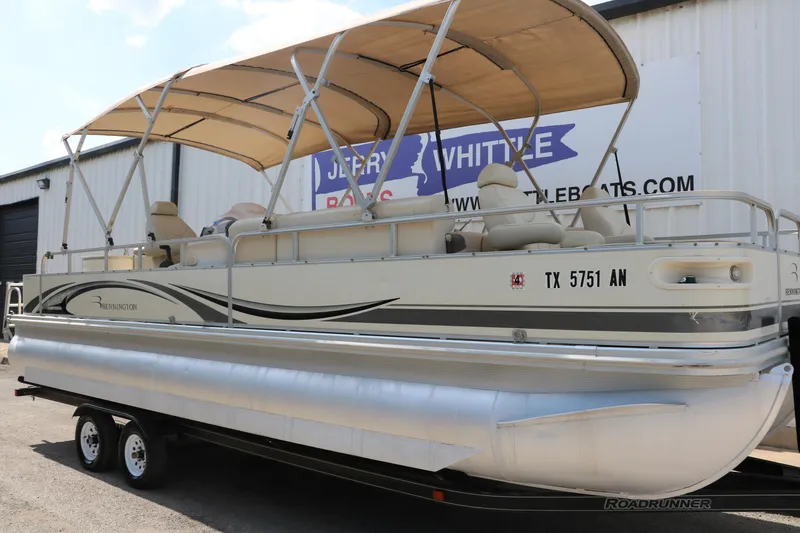Slide: The Image of 2007 Bennington 2577 RFi pontoon boat on trailer, parked outside a building. - 3