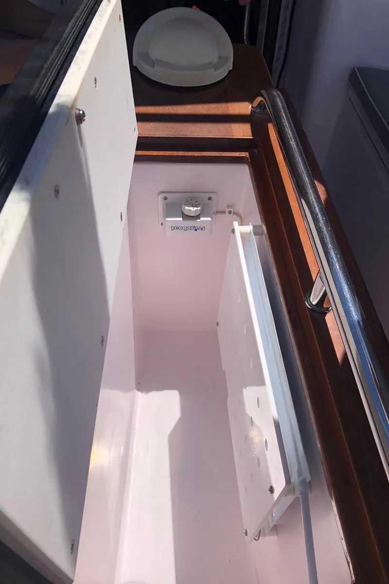 Slide: The Image of Open storage compartment on a 2019 Catalina 425 boat, featuring a white interior and metal railing. - 28