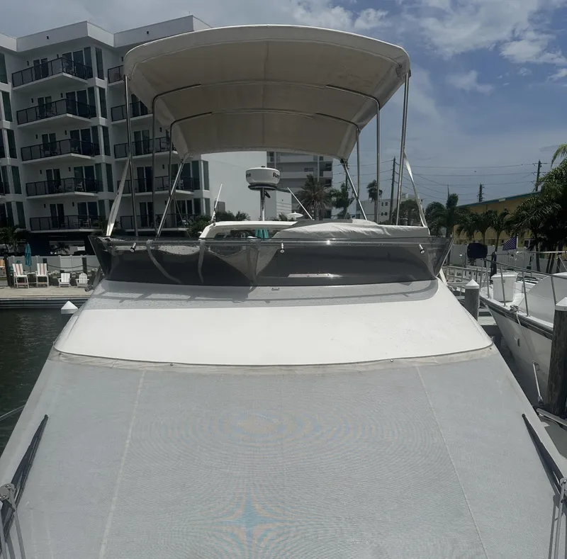 Slide: The Image of 2016 Galeon 380 Fly yacht docked near modern buildings under a cloudy sky. - 22