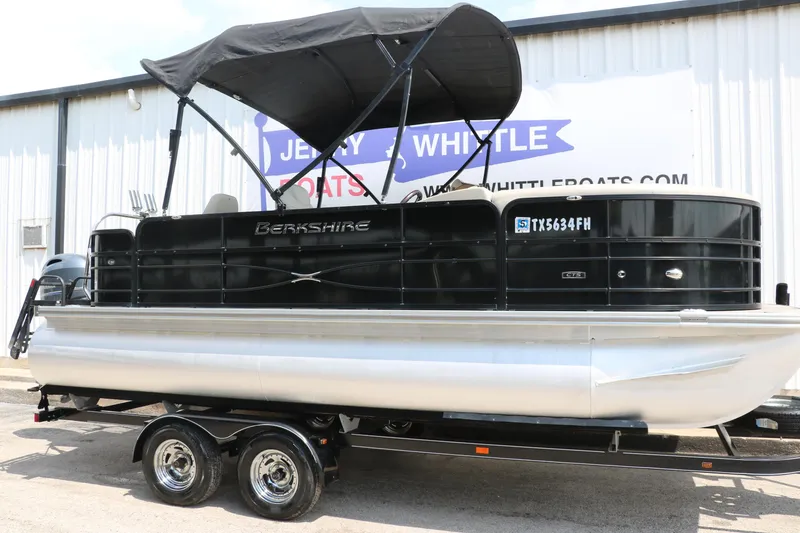 Slide: The Image of 2019 Berkshire 20RFC CTS pontoon boat on trailer, black exterior, parked outside dealership. - 1