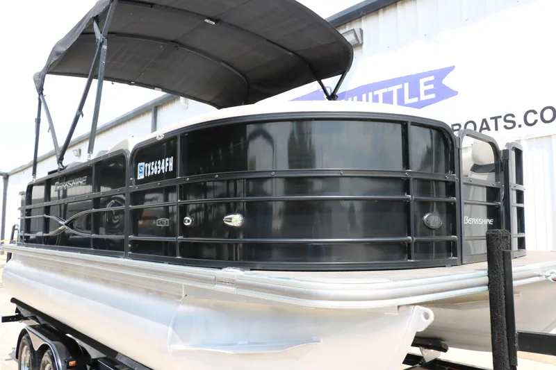 Slide: The Image of 2019 Berkshire 20RFC CTS pontoon boat with black exterior and canopy on trailer. - 13