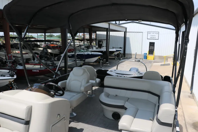 Slide: The Image of 2019 Berkshire 20RFC CTS pontoon boat interior with seating and steering wheel, in a marina setting. - 16