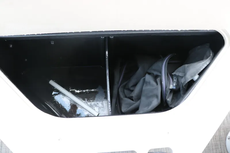 Slide: The Image of Storage compartment in a 2019 Berkshire 20RFC CTS boat, containing a pole and black bag. - 28