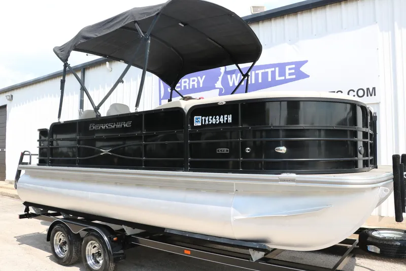 Slide: The Image of 2019 Berkshire 20RFC CTS pontoon boat on trailer, black canopy, parked outside. - 5