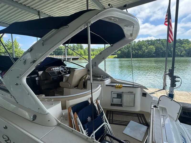 Slide: The Image of 2006 Regal 3360 Window Express boat docked by a serene lake under a covered slip. - 20