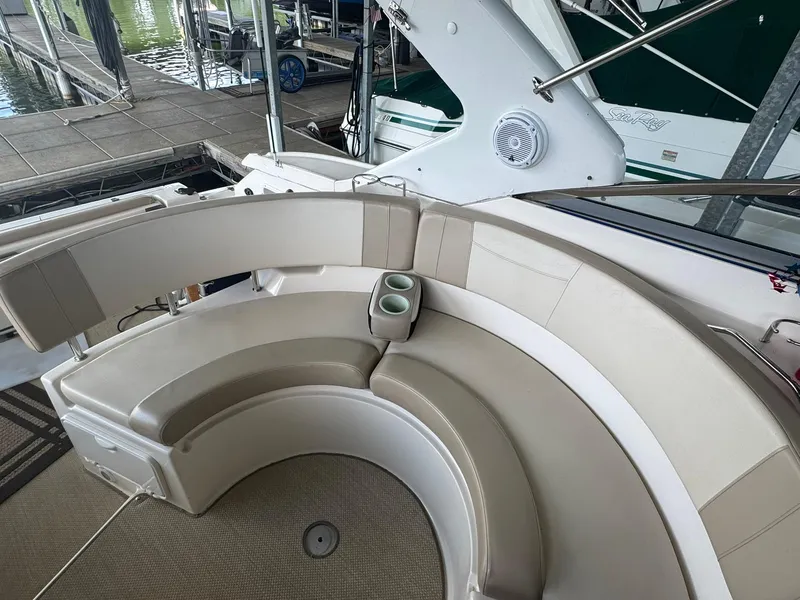 Slide: The Image of 2006 Regal 3360 Window Express boat with curved seating and cup holders at a dock. - 21
