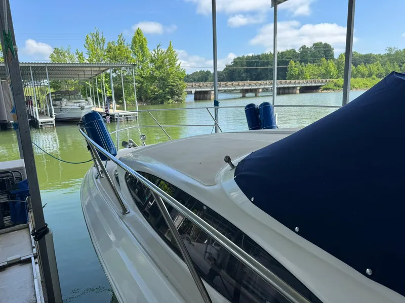 Slide: The Image of 2006 Regal 3360 Window Express docked on a serene lake under a blue sky. - 9