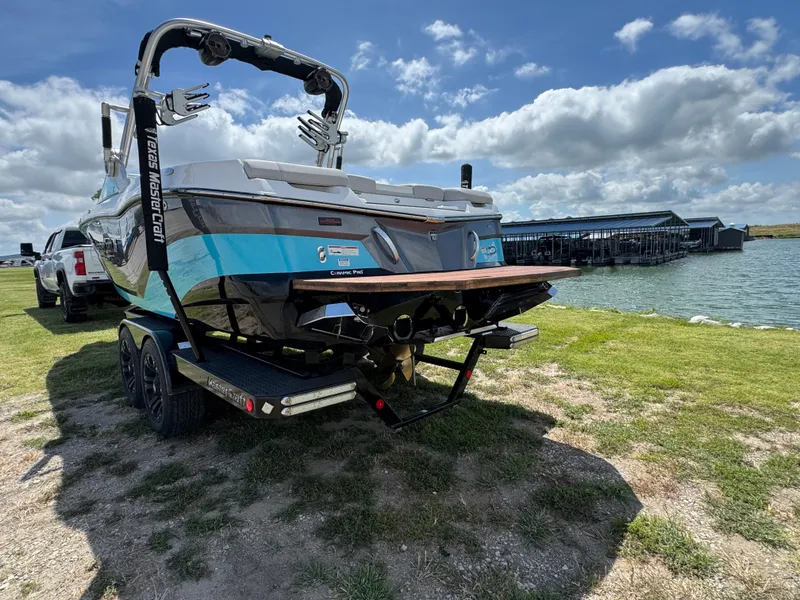 Slide: The Image of 2019 MasterCraft XT22 boat on trailer by a lake under a cloudy sky. - 10