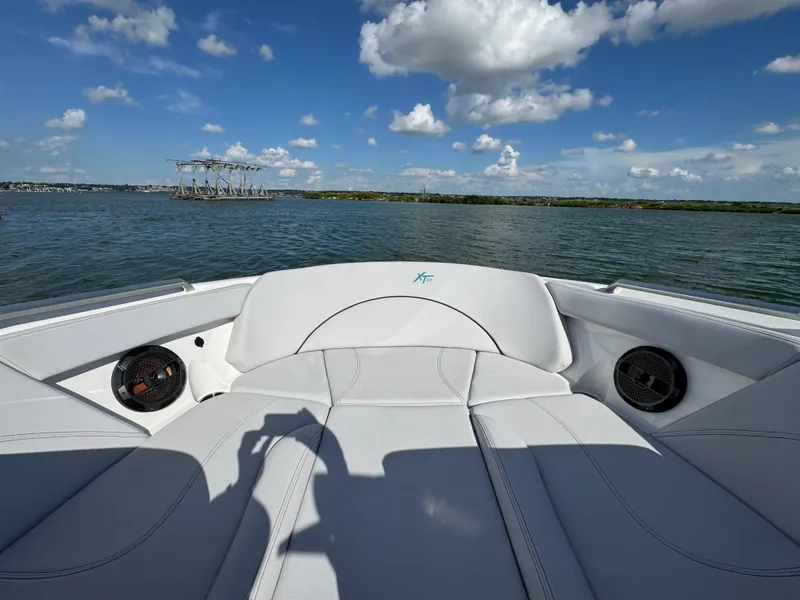 Slide: The Image of 2019 MasterCraft XT22 boat interior with speakers, on a sunny lake. - 12