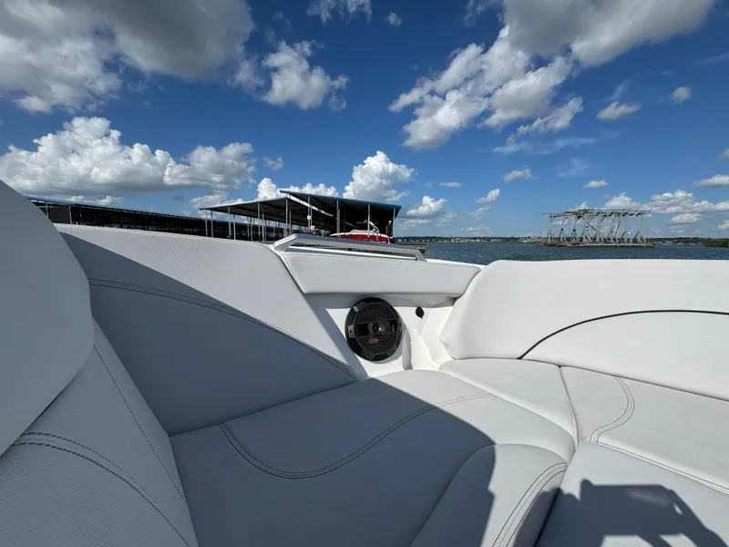 Slide: The Image of 2019 MasterCraft XT22 boat interior with white seating, speaker, and lake view under blue sky. - 13