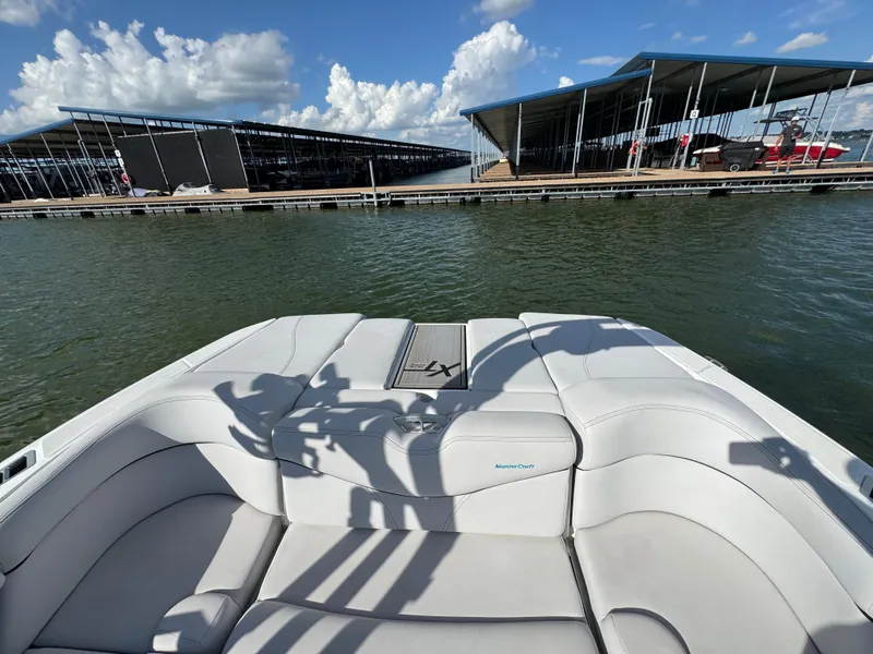 Slide: The Image of 2019 MasterCraft XT22 boat docked at marina under blue sky. - 20