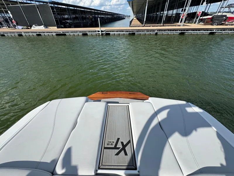 Slide: The Image of 2019 MasterCraft XT22 boat at marina, rear view with water and docks. - 21