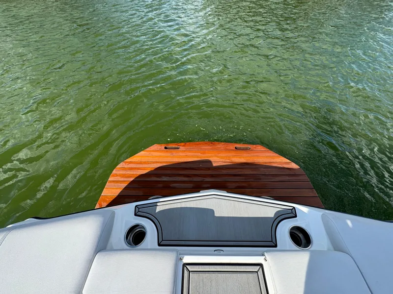 Slide: The Image of 2019 MasterCraft XT22 boat with wooden swim platform on calm water. - 22