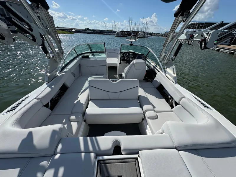 Slide: The Image of 2019 MasterCraft XT22 boat interior with spacious seating on a sunny day. - 25