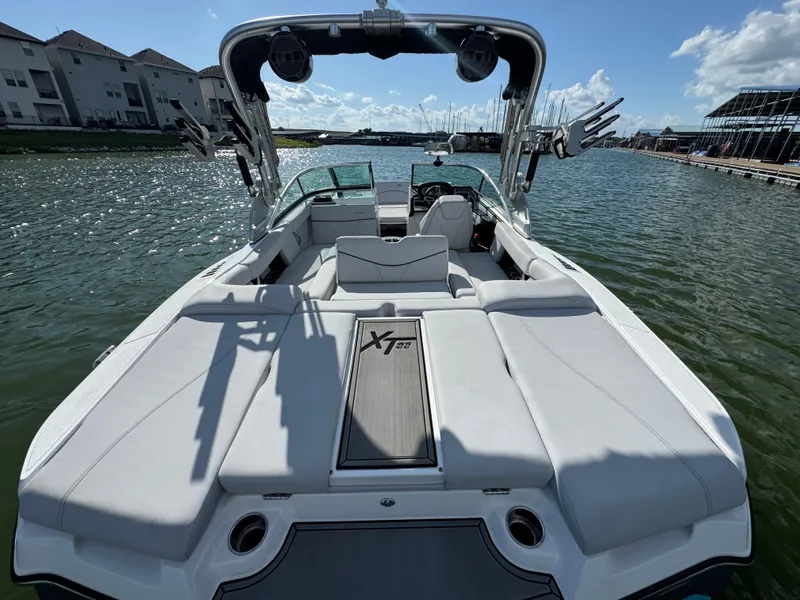 Slide: The Image of 2019 MasterCraft XT22 boat on water, showcasing spacious seating and sleek design. - 26