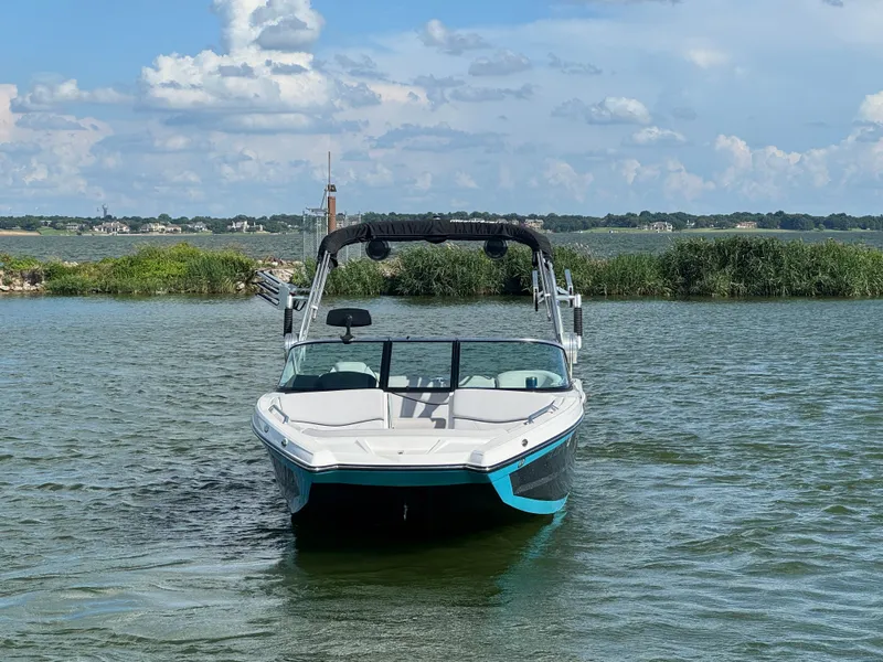 Slide: The Image of 2019 MasterCraft XT22 boat on a lake with a scenic background. - 3