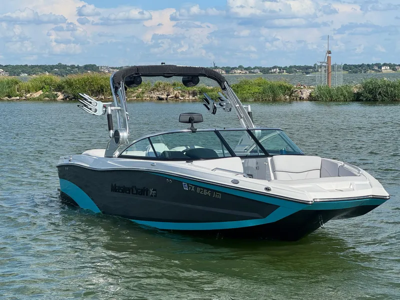 Slide: The Image of 2019 MasterCraft XT22 boat on a lake with a scenic background. - 4