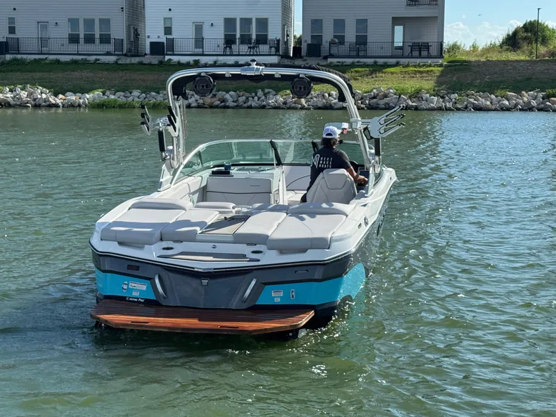 Slide: The Image of 2019 MasterCraft XT22 boat on water near modern houses. - 7