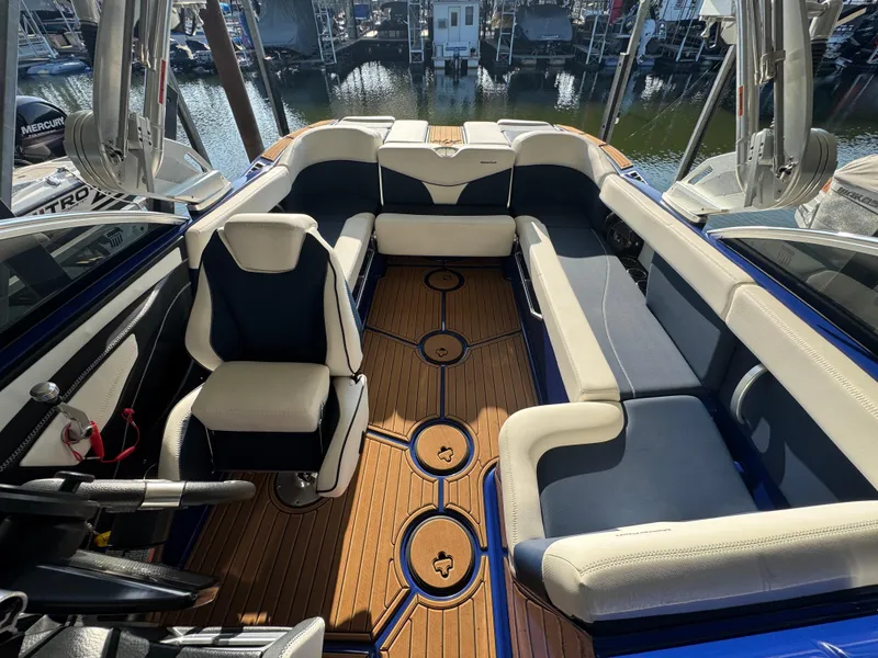 Slide: The Image of 2021 MasterCraft XT23 boat interior with luxurious seating and teak flooring. - 14