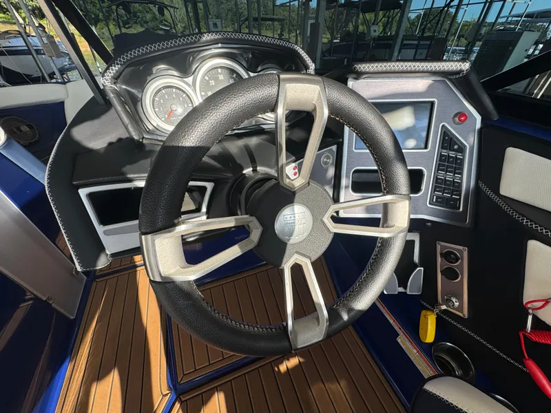 Slide: The Image of 2021 MasterCraft XT23 boat dashboard with steering wheel and control panel. - 16