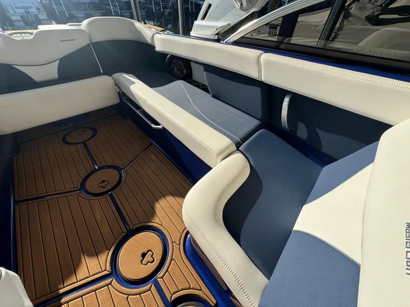 Slide: The Image of 2021 MasterCraft XT23 boat interior with cushioned seating and stylish wooden flooring. - 17