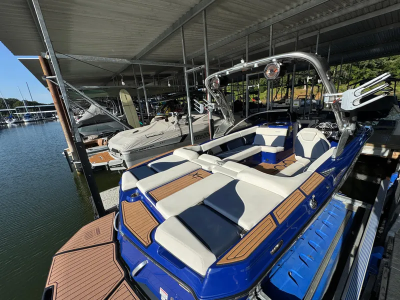 Slide: The Image of 2021 MasterCraft XT23 boat docked in a marina under a covered slip. - 9
