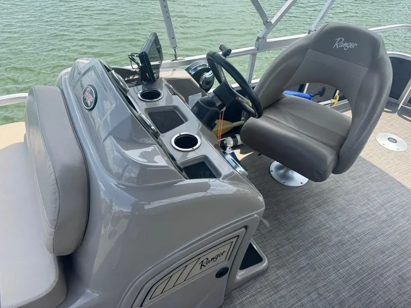 Slide: The Image of 2021 Ranger Reata 200F boat interior with steering wheel and captain's chair on water. - 10