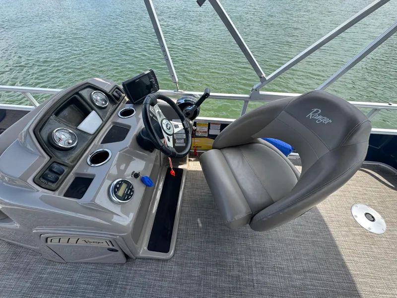 Slide: The Image of 2021 Ranger Reata 200F boat cockpit with steering wheel and control panel. - 12