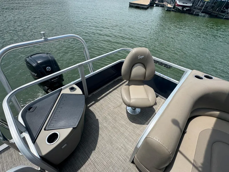 Slide: The Image of 2021 Ranger Reata 200F boat interior with seating and Mercury outboard motor on a lake. - 17