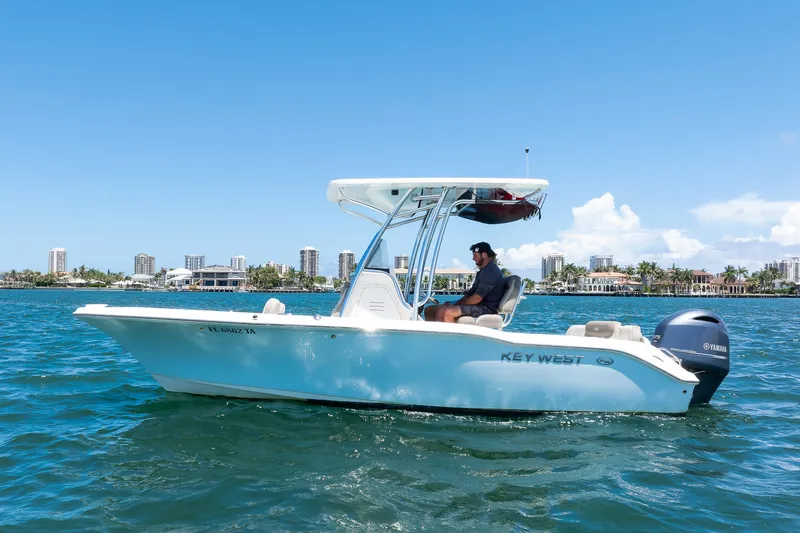 The Image of 2021 Key West 219 FS boat cruising on water with city skyline in background. - 1