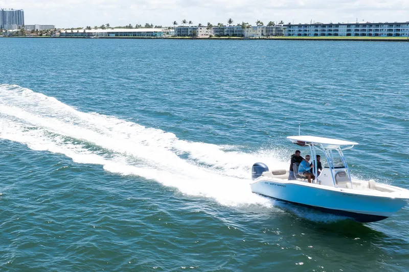 Slide: The Image of 2021 Key West 219 FS boat cruising on blue ocean near coastal buildings. - 10