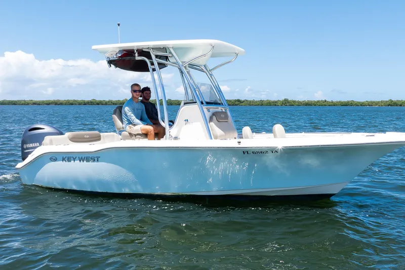 Slide: The Image of 2021 Key West 219 FS boat cruising on open water with two passengers. - 15