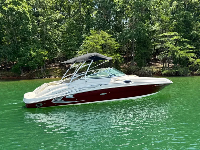 Slide: The Image of 2006 Sea Ray 270 Sundeck boat on a serene lake with lush green trees. - 11