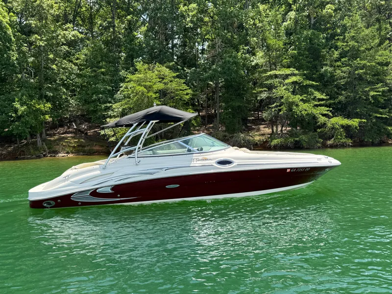 Slide: The Image of 2006 Sea Ray 270 Sundeck boat on a serene lake with lush green trees. - 12